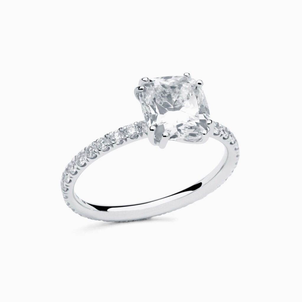 Anillo solitario pavé Elsa G en oro 18K con diamante central talla cushion y brazo con diamantes